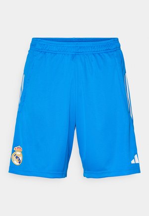 Pantaloni sportivi blu con vita elastica, strisce bianche sui lati e logo ricamato del Real Madrid sulla gamba sinistra. Tessuto di trama liscia.