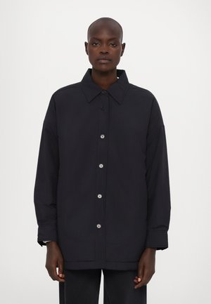 Marineblaue oversized Jacke aus leichtem Material mit klassischem Kragen, vorderem Knopfverschluss und seitlichen Taschen.