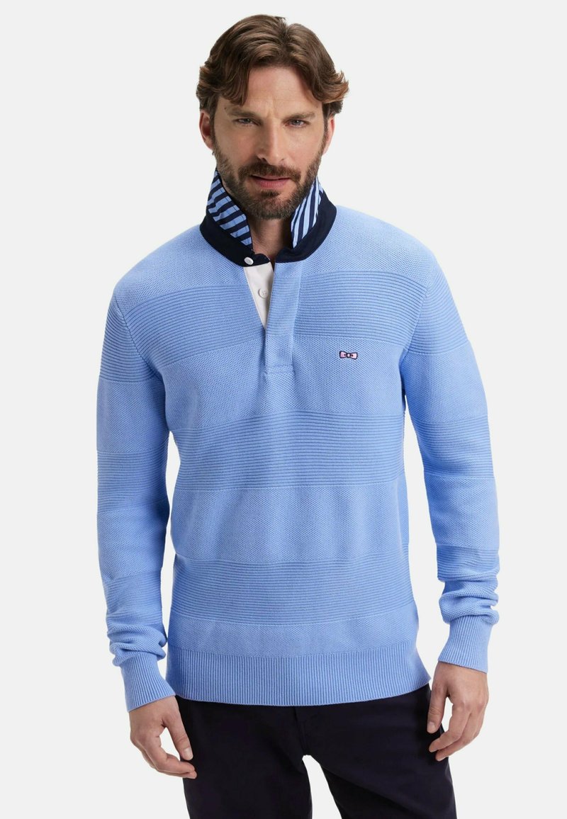 Pull-over bleu clair à manches longues avec des rayures horizontales texturées, un col rayé bleu marine et blanc, et une patte de boutonnage. Petit logo sur la poitrine.