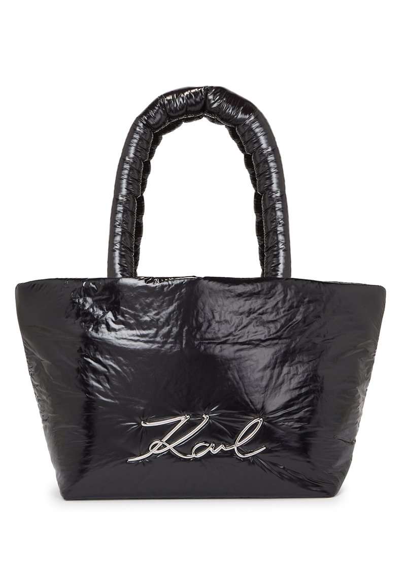 Černá nadýchaná taška přes rameno s texturovaným, lesklým materiálem a výrazným logem ve stříbrném písmu na přední straně. Obsahuje polstrovanou rukojeť.