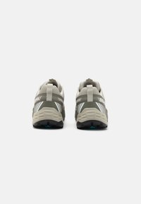 Trailrunning schoenen met een grijs en beige bovenwerk van mesh, een getextureerde rubberen buitenzool, een prominente hielcounter en contrasterende blauwe accenten.