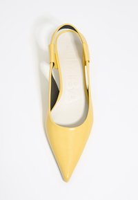 Gelbe Lackleder-Slingback-Pumps mit spitzem Zeh, die ein elegantes Design aufweisen. Die schwarze Innensohle kontrastiert mit dem leuchtenden Obermaterial.