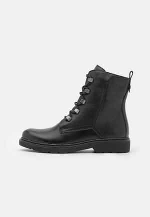 Stivaletti in pelle nera con punta arrotondata, chiusura con lacci e dettagli metallici rettangolari. Finitura texturizzata e suola in gomma robusta.