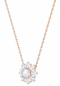 Collier en or rose avec un pendentif en forme d'étoile éclatante, comportant une pierre centrale ronde et claire entourée de pierres claires rectangulaires effilées.