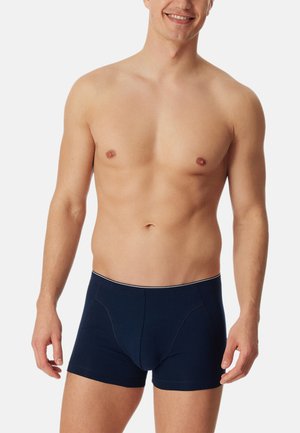 Boxers en coton bleu marine avec un design ajusté, dotés de coutures blanches contrastantes le long de la taille et des ouvertures de jambe.