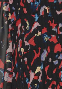 Tissu à motifs présentant des formes abstraites en rouge, bleu, rose et or sur un fond noir. Comprend des plis texturés.