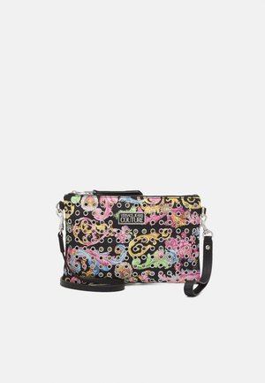Pochette noire Versace Jeans Couture avec imprimé baroque coloré, œillets argentés et sangle de poignet noire amovible.