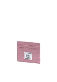 Portafoglio in tessuto di colore rosa pallido, con quattro scomparti. Etichetta Herschel ben visibile cucita sul davanti, con un accento a righe sul lato.