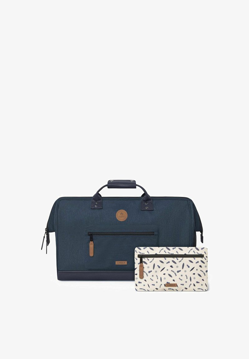 Sac de sport bleu marine avec une finition texturée, des accents en cuir, une poche zippée à l'avant et une pochette assortie à motif crème et bleu marine.