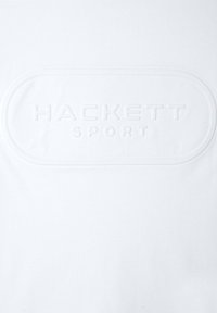 Hvid bomulds t-shirt med præget "HACKETT SPORT" logo i midten, med en glat tekstur og en rund form.