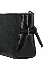 Bolso de mano de cuero negro con un acabado texturizado, acentos brillantes y cierre de cremallera. Presenta una correa desmontable y herrajes en tono plateado.