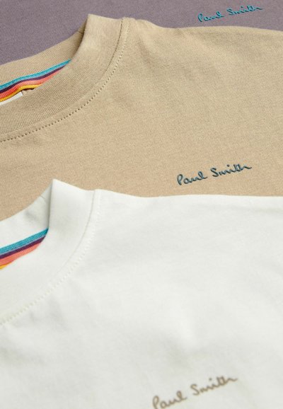 Három póló: egy bézs, egy fehér, mindkettőn a "Paul Smith" hímzett, kontrasztos színekkel. Mindegyiknek színes csíkos nyaka van.