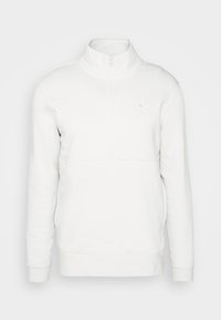 Pull-over à manches longues blanc Nike avec col à demi-fermeture éclair et petit logo brodé sur le côté gauche de la poitrine.