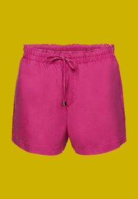 Shorts décontractés rose vif avec taille élastique et cordon de serrage sur un fond uni jaune moutarde.