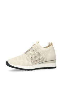 Beige stickad sneakers med metalliska accenter, en flexibel sula och en slip-on design. Texturerad ovandel med ett andningsbart meshmönster.