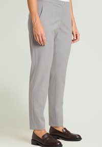 Lichtgrijze op maat gemaakte broek met een subtiel polkadotpatroon, rechte pasvorm, zijzakken en een tailleband met een knoopsluiting.