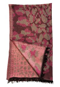 Couverture tissée avec des motifs floraux et géométriques dans des nuances de rose et de marron, présentant des bords à franges et une surface texturée.
