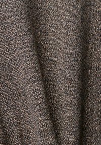 Gros plan sur un tissu tricoté gris foncé montrant une texture détaillée et des boucles de fil individuelles.