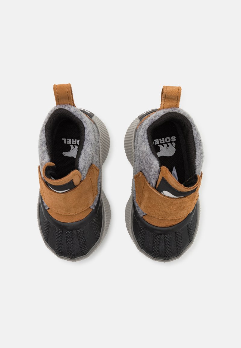 Chaussures en tissu brun et gris avec une semelle noire texturée. Elles sont dotées d'une sangle velcro, d'un dessus en laine grise et d'un doublure noire pour plus de chaleur.