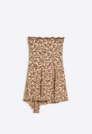Béžové mini šaty bez ramínek s hnědou květinovou krajkou a vroubkovanými okraji, se asymetrickým lemem.