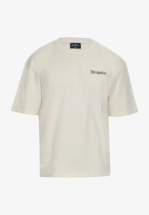 Cremefarbiges Baumwoll-T-Shirt mit lockerem Schnitt. Mit kurzen Ärmeln und einem kleinen braunen "Dropsize"-Logo, das auf der linken Brust gestickt ist.