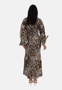 Sukienka maxi w zwierzęcy wzór w cętki, z długimi, zwiewnymi rękawami, przewiązywana w talii i wykonaną z miękkiego, lekkiego materiału w neutralnych odcieniach beżu i brązu.