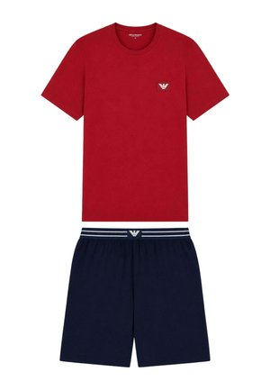 T-shirt rossa a manica corta con piccolo logo sul petto abbinata a pantaloncini blu navy con vita elastica, fascia a strisce e logo centrato.