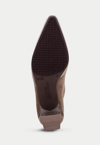Suola di scarpa in suede marrone con fondo in gomma nera texturizzata. Presenta una forma affusolata e un leggero tacco accentuato da strisce orizzontali.