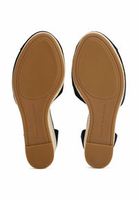 Black fabric sandals with a textured sole, rubber grip, and tan accent. Features a closed toe and cushioned insole for comfort.