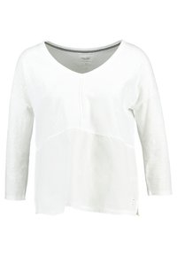 Vit V-ringad långärmad tröja med en texturerad frampanel och kontrasterande svart och vit randig inre krage.