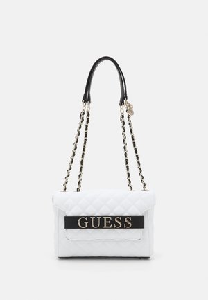 White quilted shoulder bag with black leather and gold chain straps, featuring a black band with gold "GUESS" logo on front flap.