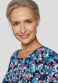 Bluse mit floralen Mustern auf navyfarbenem Grund, bunten Blumenmotiven in Pink und Blau, rundem Halsausschnitt und weichem Stoff.