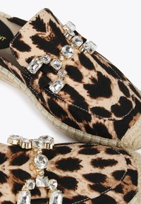 Espadrile s uzorkom leopard, od bež tkanine, ukrašene prozirnim kamenčićima i jutenom potplatom, s zaobljenim vrhom i šivenim detaljima.