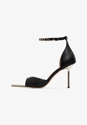 Czarna sandał na wysokim obcasie z ostrym noskiem, górą z gładkiej skóry, paskiem na kostkę z klamrą i metalowym szpilkowym obcasem.
