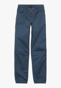 Pantalones elásticos azules con cinturilla ajustable, puños elásticos y bolsillos laterales. Hechos de una tela ligera con una textura suave.