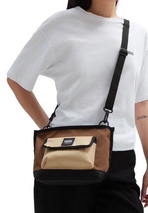 Sac bandoulière marron et beige avec des accents noirs, tissu texturé, bandoulière réglable, poche à rabat à l'avant et étiquette de marque.