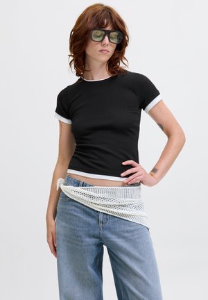 Black short-sleeve t-shirt with white trim, paired with high-waisted blue jeans and a white knit belt wrapped around the waist.