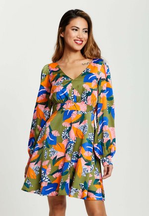 Floral dress in green fabric with long, puffed sleeves. V-neckline, cinched waist, and vibrant patterns in blue, pink, and orange tones.