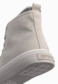 Lichtgrijze high-top sneaker van suède met een gestructureerde rubberen zool, voorzien van witte accenten en een logo op de hiel.