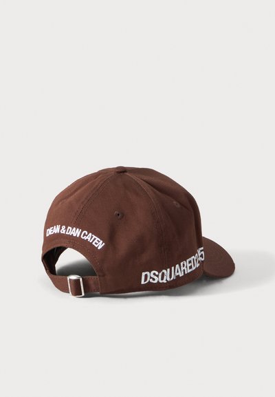 Gorra de béisbol marrón con correa ajustable, texto blanco "DEAN & DAN CATEN" en la parte trasera y "DSQUARED2 25" en el lado.