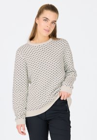 Hellbeige gestrickter Pullover mit schwarzen Herzmustern, rundem Halsausschnitt und gerippten Bündchen. Weiche Textur, lockere Passform und seitliche Schlitze am Saum.