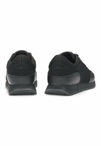 Scarpe atletiche nere con tomaia in mesh e pelle, punta arrotondata, collo imbottito e suola in gomma testurizzata. Presenta logo sul tallone e sulla linguetta.