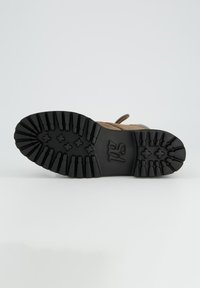 Stivale in pelle marrone con una spessa suola in gomma nera con scanalature profonde e logo impresso. Lacci in tessuto marrone sulla parte superiore.
