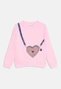 Rosa sweatshirt med rundad hals, med en hjärtformad ficka som har lager av texturer och ett marinblått band dekorerat med mindre hjärtan.