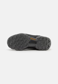 Suela de zapato deportivo negro con suelas estampadas para tracción, con un logo amarillo de Continental y bordes reforzados para mayor durabilidad.
