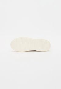 Weißer Gummisohlen mit linearem Profil und glatten Kanten, die eine abgerundete Form und minimale Designdetails aufweist.