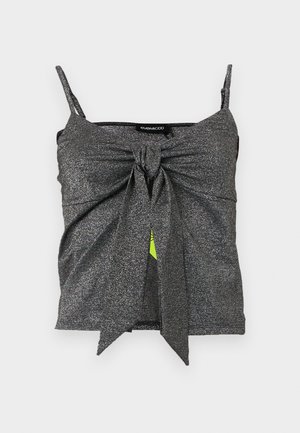 Top corto sin mangas de color plata gris brillante, con tirantes finos y un gran nudo en el centro del frente.