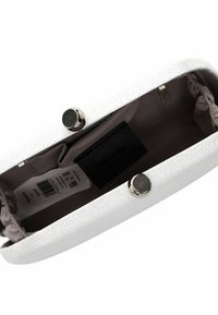 Bolso de mano blanco texturizado con un interior liso, herrajes plateados, cierre a presión y un forro sutil. Cuenta con una etiqueta interior y un bolsillo.