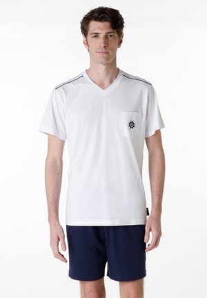 T-shirt bianco con scollo a V e tasca frontale, caratterizzato da un logo di timone blu navy. Include delicate righe blu navy sulle spalle.