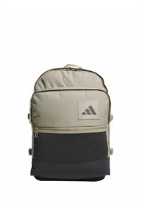 Mochila de lona gris con una base negra texturizada, compartimentos con cremallera y una etiqueta con el logotipo. Cuenta con correas ajustables y un asa superior.